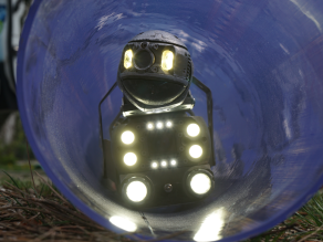 Ein Kanalroboter in einem durchsichtigen Abwasserrohr bei einer Ausstellung.