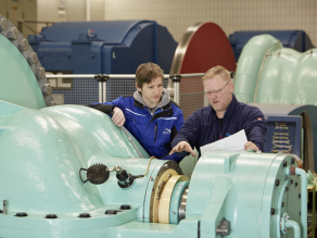 Einem Azubi werden Zusammenhänge von einem Ausbilder erklärt.