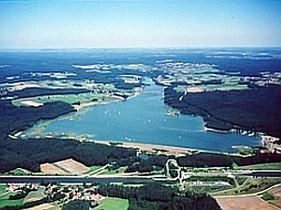 Die Luftaufnahme zeigt vom unteren zum oberen Bildrand zuerst den Main-Donau-Kanal mit einem Schleusenbauwerk, dann das Absperrbauwerk des Rothsees; darüber das Staubecken und die Vorsperre.