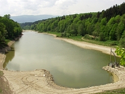 Der Surspeicher in einer Niedrigwasser-Periode. Der Blick richtet sich vom Absperrbauwerk am unteren Bildrand Seeaufwärts. Deutlich sind die trocken gefallenen Uferbereiche an dem vom Wald umgebenen Staubecken zu erkennen.