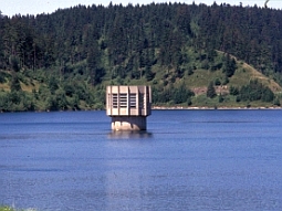 Das Bild zeigt den von Wasser umgebenen Entnahmeturm der gut gefüllten TWT Mauthaus. Im Hintergrund bewaldeten Hänge, wie sie für den Frankenwald typisch sind.