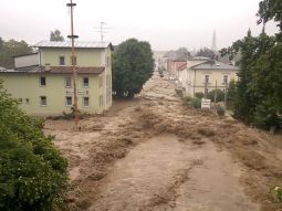 Große Wassermassen strömen entlang einer Straße in Simmbach am Inn.