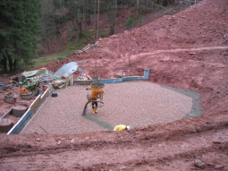 Beginn des Baus der wasserundurchlässigen Betondecke auf der Kiesschüttung.