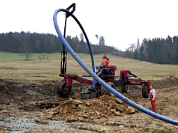 Der Pflug fährt voraus und öffnet den Boden für die Rohleitung und führt diese in den Boden. Vom unmittelbar dahinter fahrenden Fahrzeugteil wird die Rohrleitung abgespult.