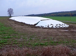 Futtermittel wird auf einem Feld in Form einer Flachmiete gelagert.