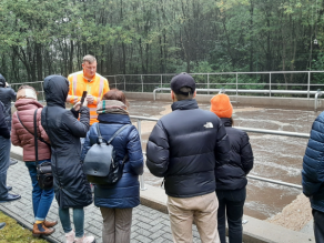 Personengruppe neben einem Klärbecken