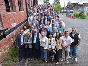 Gruppenbild mit den Teilnehmern der Veranstaltung auf der Zugangstreppe im Außenbereich