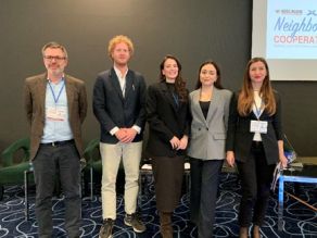 Gruppenfoto mit den fünf Referenten der zweiten Vortragsrunde des Panel Gewässerschutz/ Klärschlammmanagement auf der Bühne des Tagungsraumes.