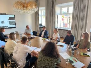 Besucherdelegation aus der Ukraine mit den Referenten des Workshops an einem Tisch im kleinen Sitzungssaal der Regierung von Niederbayern.