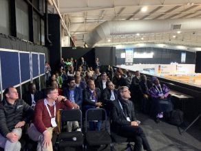 Teilnehmer des Workshops in der über dem Messeareal angeordneten Veranstaltungsebene mit Blick auf verschiedene Stände.