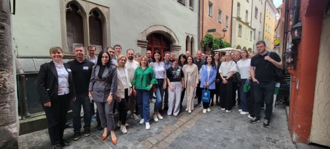 Gruppenfoto mit den Teilnehmern der Veranstaltung in der Gasse vor dem Haus der Begegnung in Regensburg.