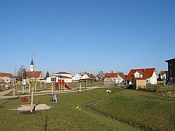 Neubaugebiet mit Spielplatz. Sammlung und Ableitung des Niederschlagswassers erfolgen durch eine grabenähnliche Vertiefung im Gelände. Da der Graben nur nach Regenfällen kurz Wasser führt, kann die Fläche meistens als Spielfläche genutzt werden